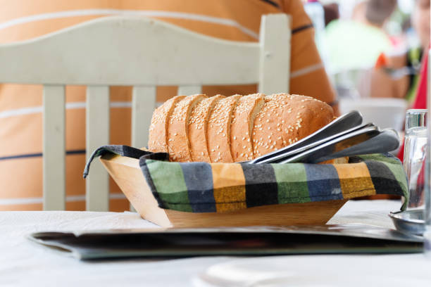 Close up of a bread sliced on a wooden basket, placed on a table of a traditional Greek tavern in Volos, Greece.
