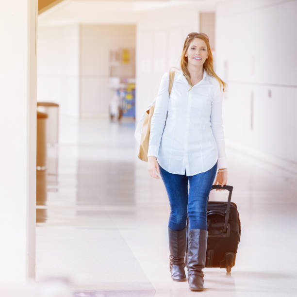 istock Cheerful traveler walks through airport with rollerboard 961525266