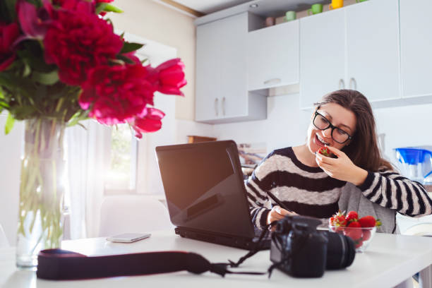istock Freelancer photographer working at home. Woman works on laptop using camera and pen tablet. Start up 961528746