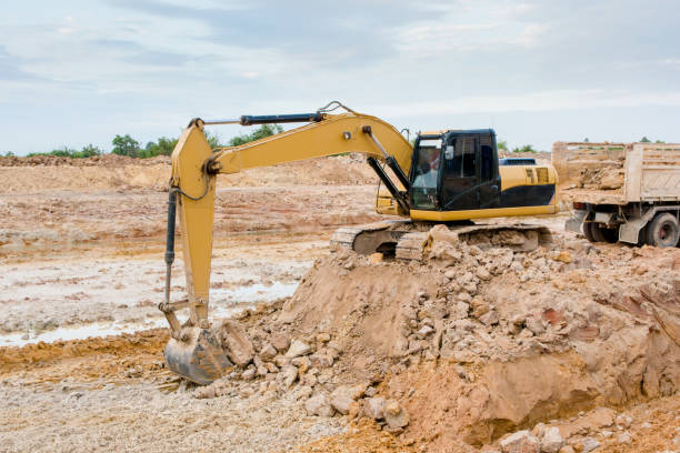 istock Yellow excavator machine working earth moving works at construction site 961529076