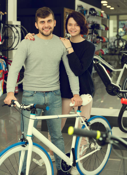 istock adult smiling couple standing with bicycle 961529772