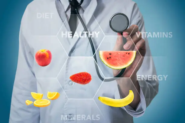 Doctor with stethoscope and fruits for healthy food on a blue background