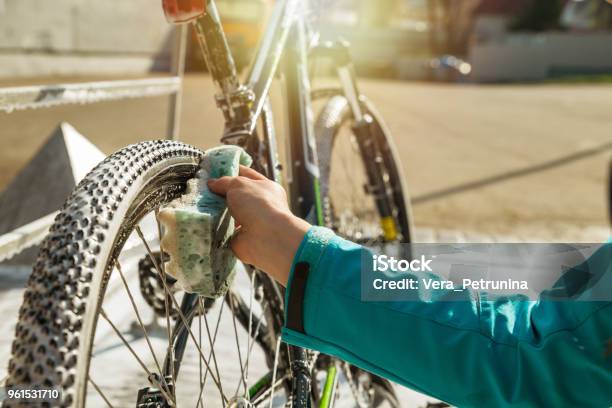 Rueda De Bicicleta Con Esponja De Limpieza De La Mano De La Mujer Foto de stock y más banco de imágenes de Bicicleta