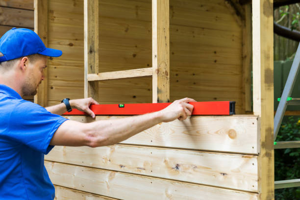 istock shed construction - worker check the level of wooden plank wall 961531850