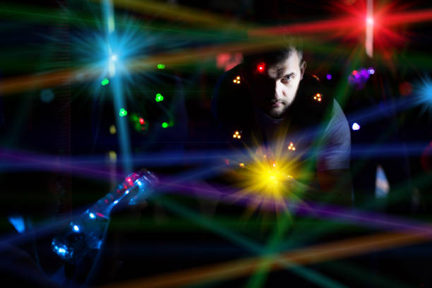 Portrait of excited guy laser tag player with laser pistol in room with bright beams