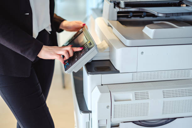 donna che preme il pulsante su una copiatrice in ufficio - documento stampato foto e immagini stock