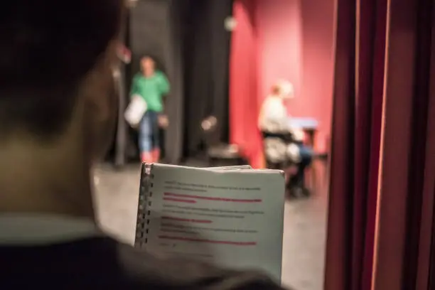 Actor Reading Script From Backstage for Assistance and Preparation.