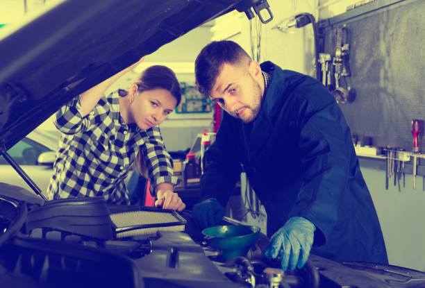 istock two masters are standing near car and replacing the oil 961552654