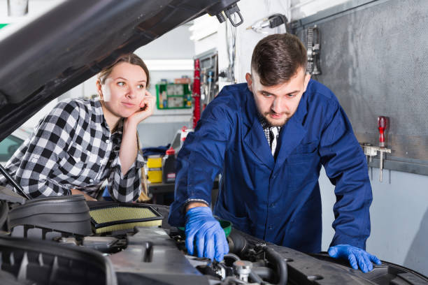 istock Female master with foreman are replacing the oil in car 961552686