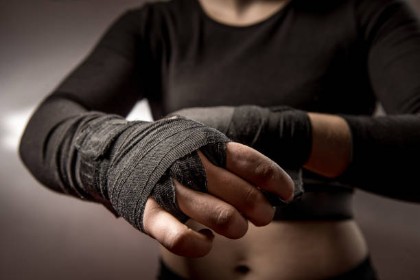 istock Young Woman Boxer Tying Protective Bandage Around Her Wrists 961553200
