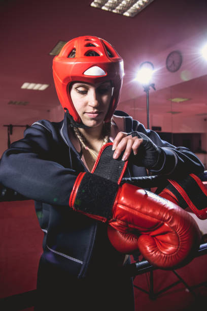istock Young Woman Boxer Putting on Boxing Gloves 961553274