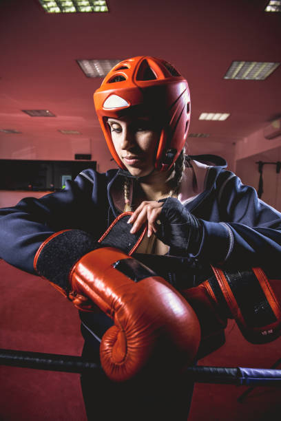 istock Young Woman Boxer Putting on Boxing Gloves 961553280