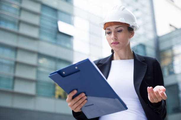 istock Woman architector in suit and hat is dissatisfieded of documents with project 961555406