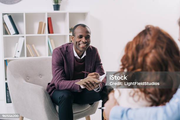 Smiling African American Psychiatrist Talking To Young Couple Stock Photo - Download Image Now