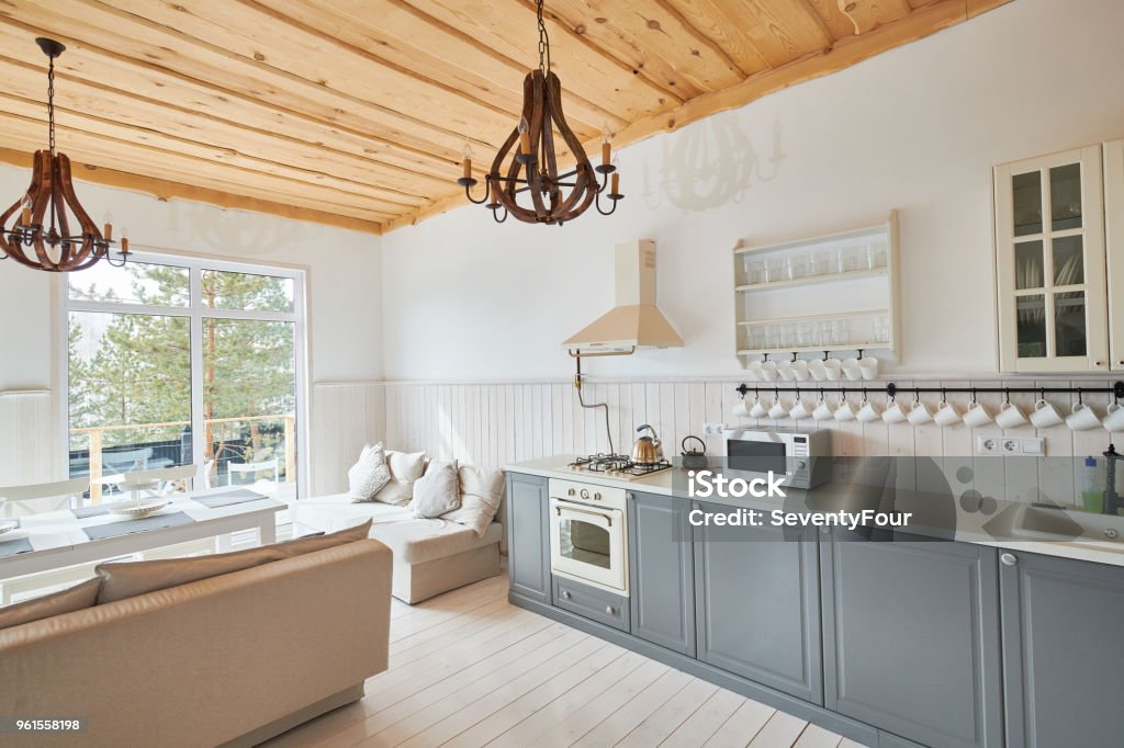 Scandinavian Dining Room Interior Wide angle shot of modern kitchen interior with grey counters and white furniture set in minimalistic Scandinavian design, copy space, nobody Kitchen Stock Photo