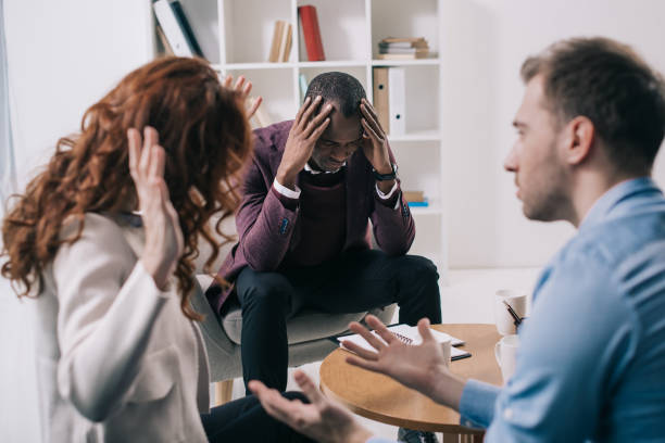 istock Frustrated counselor and young divorcing couple in office 961560522