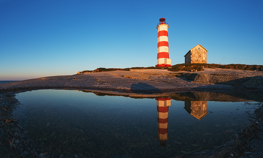 Sambro Island Lighthouse reflected in early morning light.
