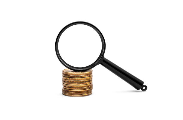istock Magnifying glass on the stack of coins on white background. 961572980