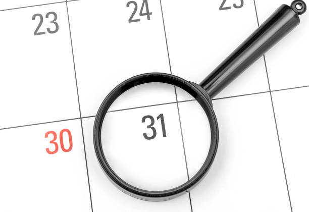Magnifying glass on calendar. Focused on last day of month. Magnifying glass on calendar. Focused on last day of month. december 31 stock pictures, royalty-free photos & images