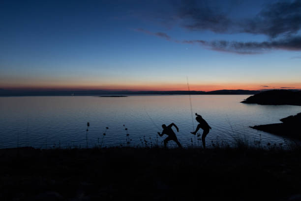 istock Two silhouettes walking funny next to the sea 961573392