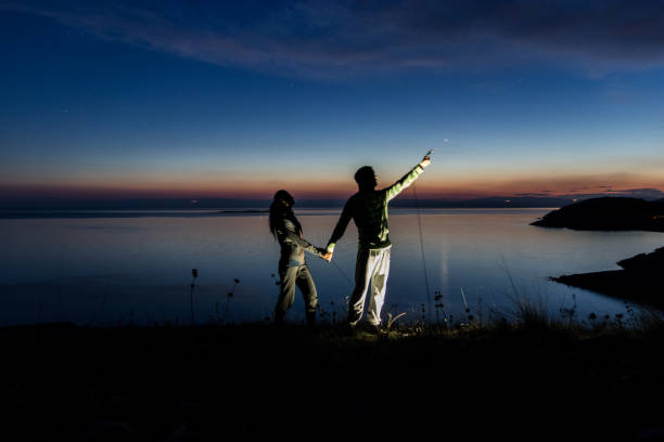 istock Couple holding hands and looking at stars 961576204