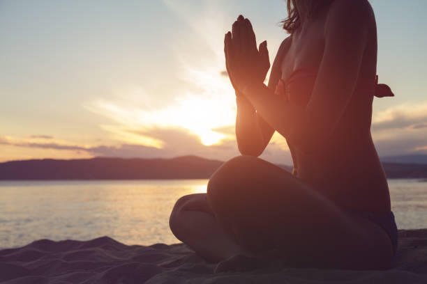 istock Woman practicing yoga on the beach. 961581180