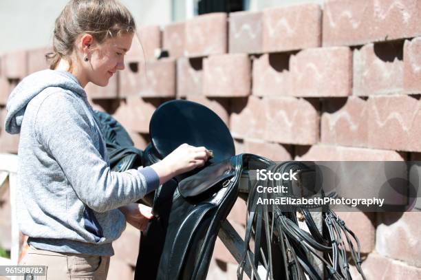 Teenage Girl Equestrian Cleans Black Leather Horse Saddle Stock Photo - Download Image Now