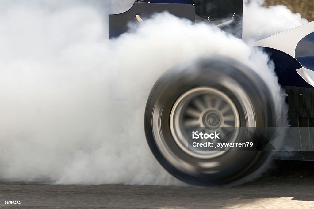open-wheel single-seater racing car Car Wheelspin 2006 open-wheel single-seater racing car Grand Prix car smoking its super slick tires.  The open-wheel single-seater racing car Grand Prix car is engulfed in white smoke. Tire - Vehicle Part Stock Photo