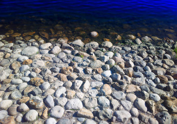 A wave splashing over a few stones. Shutter speed set to make water look alive and moving.