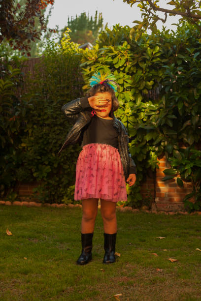istock Child dressed up as a rocker with leader jacket covering eyes. Sunset 961606070
