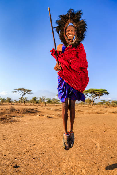 Warrior from Maasai tribe performing traditional jumping dance, Kenya, Africa African warrior from Maasai tribe performing a traditional jumping dance, central Kenya, Africa - Mount Kilimanjaro on the background. Maasai tribe inhabiting southern Kenya and northern Tanzania, and they are related to the Samburu. kenyan man stock pictures, royalty-free photos & images