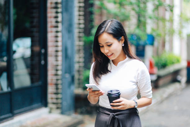 istock Young Malaysian woman reading messages on her phone while having a coffee break 961619348