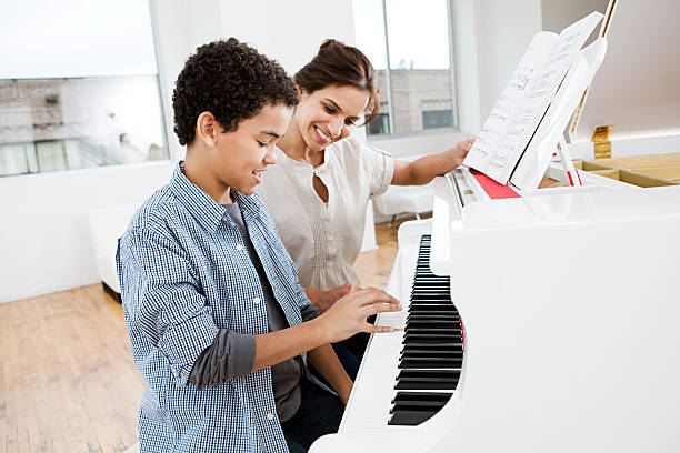 frau, die klavier-unterricht für jungen - music lessons stock-fotos und bilder