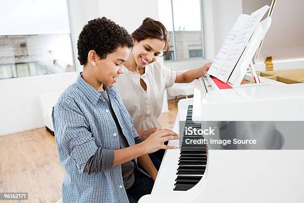 Woman Giving Piano Lesson To Boy Stock Photo - Download Image Now - Piano, Learning, Music