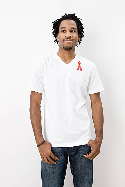 homme avec ruban rouge - aids awareness ribbon photos et images de collection