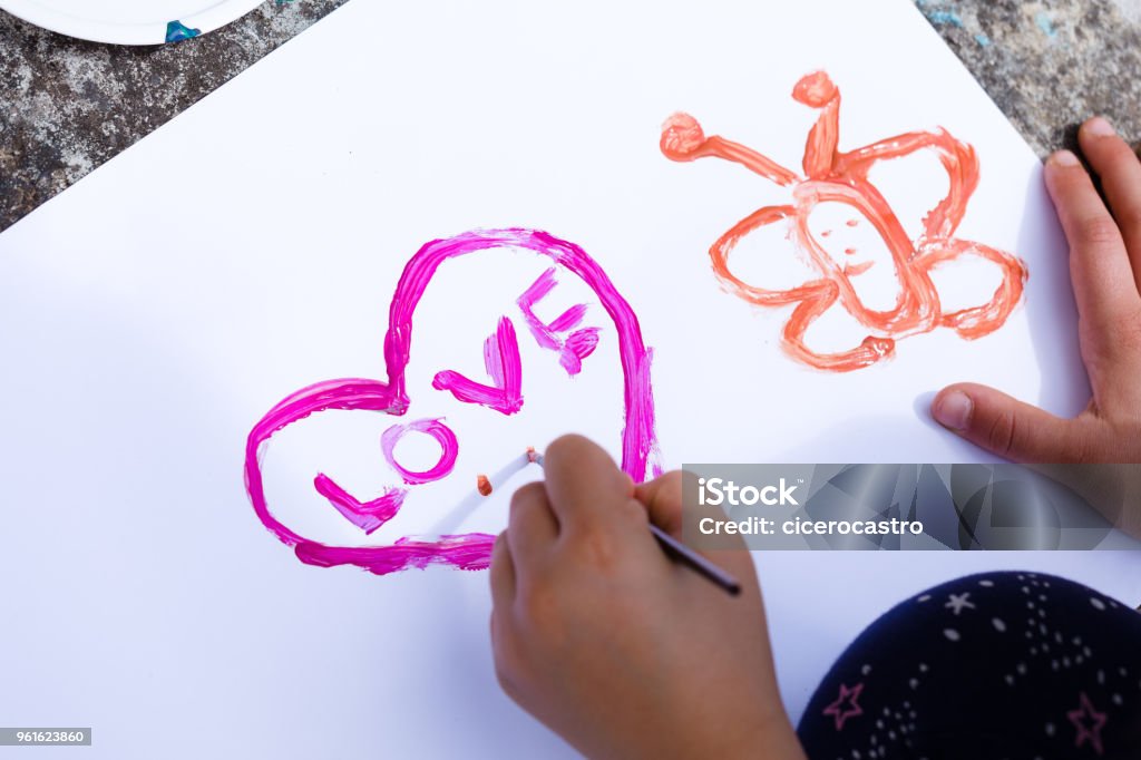 A heart shape on paper Kid drawing a heart shpe on paper with a pink brush Art Stock Photo