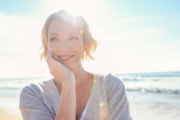 schöne reife frau porträt am strand. - women mature adult human face smiling stock-fotos und bilder