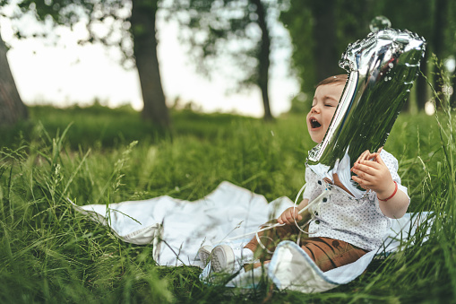 Baby boy playing with soap bubbles and balloon