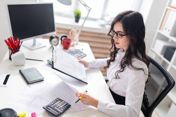 istock A young girl sits at the office desk and checks documents. 961634044