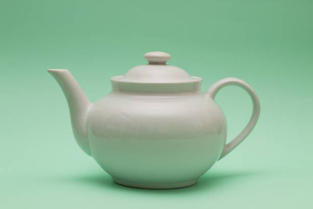 istock white Porcelain teapot on green background 961634880