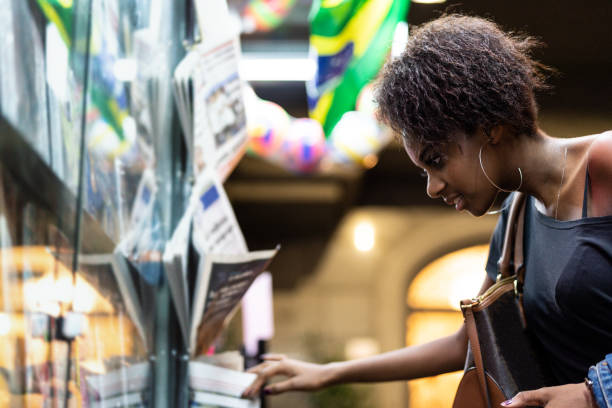 Afro Young Woman looking for the news at newsstand Brazilian woman in Sao Paulo news stand stock pictures, royalty-free photos & images