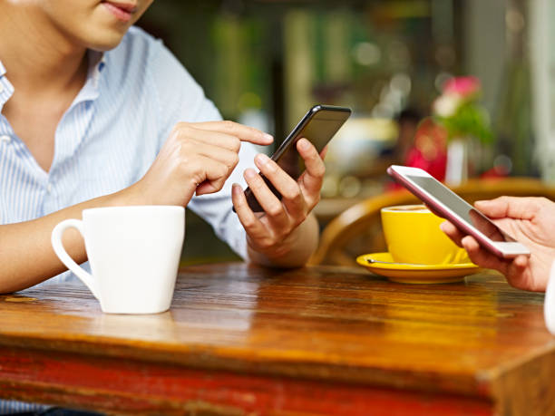 istock young asian couple playing with cellphone in coffee shop 961645330