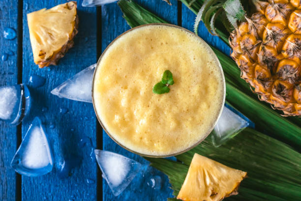 istock Top view of Pineapple smoothie with Fresh Pineapple fruit on blue wooden table 961663756