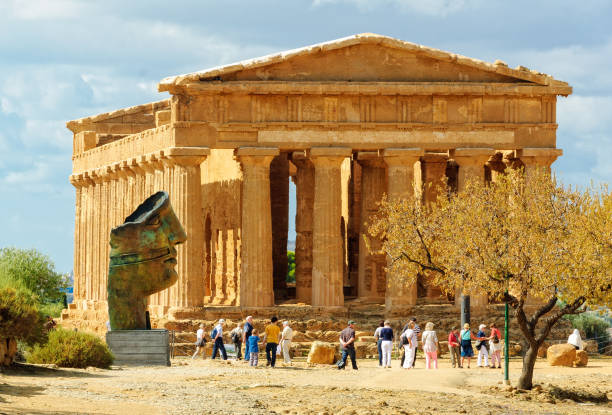 Agrigento, Sicily, Italy - October 19, 2011: Sculpture by Igor Mitoraj and Temple of Concordia