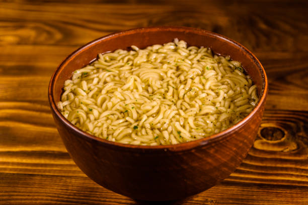 istock Ceramic bowl with prepared instant noodles on wooden table 961667648