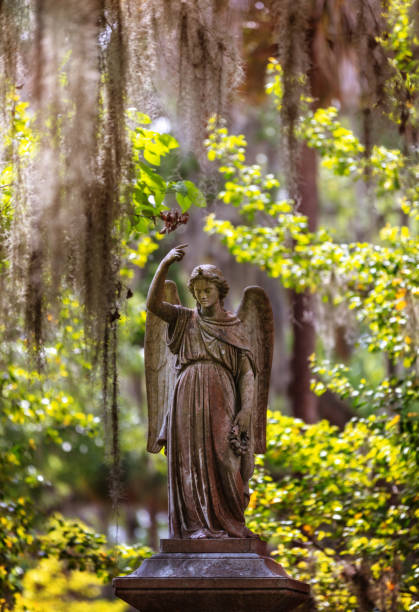 Statue of an angel among Spanish Moss covered trees in Bonaventure Cemetery, Savannah, Georgia, USA.