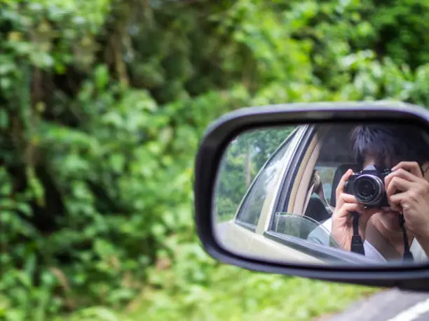 Photo of Vintage effect on man taking picture of himself from wing mirror