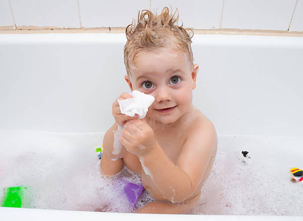 Baby girl playing in the bath stock photo