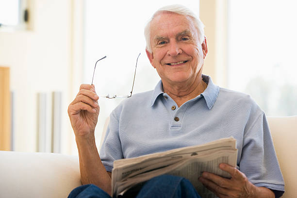 istock Smiling Elderly man in the living room reading newspaper 96169046
