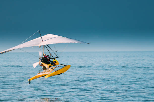 Batumi, Adjara, Georgia. Motorized Hang Glider With Muslim Woman Take Off Frow Sea In Sunny Summer Day Batumi, Adjara, Georgia - September 10, 2017: Motorized Hang Glider With Muslim Woman Take Off Frow Sea In Sunny Summer Day. Muslim People Having Fun para ascending stock pictures, royalty-free photos & images